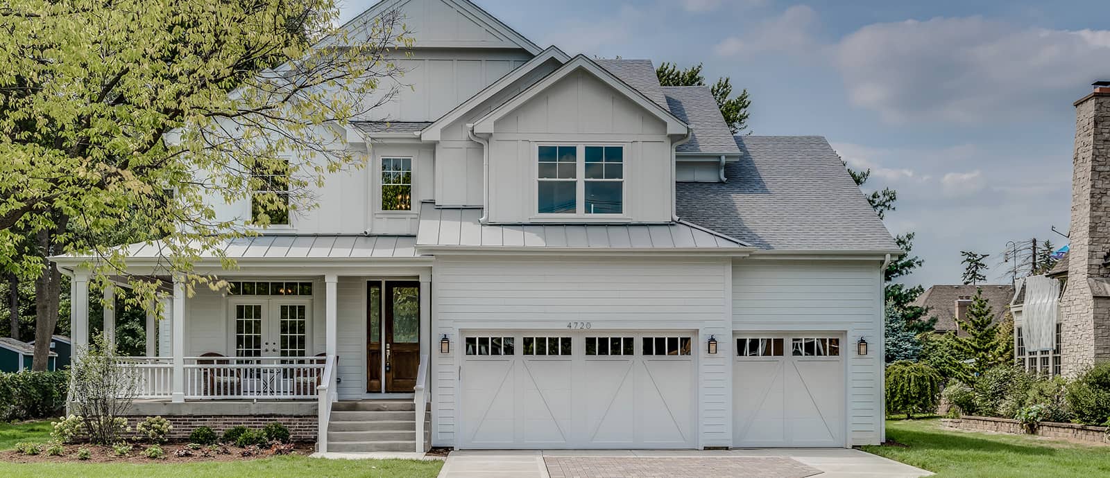 Front exterior of a gray two-story home with white trim and a two-car garage